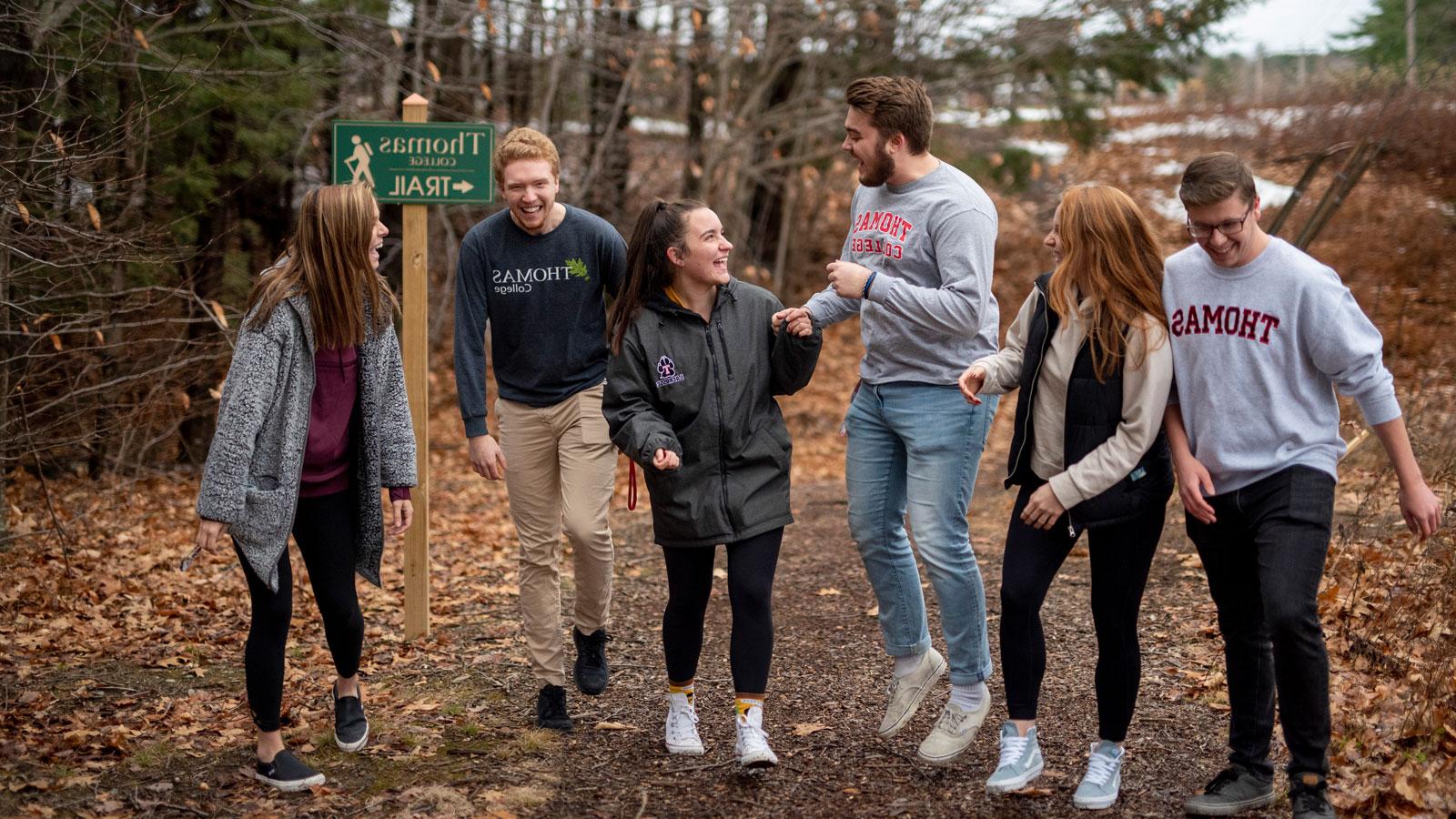 6 students walking on a hiking trail at Thomas College.